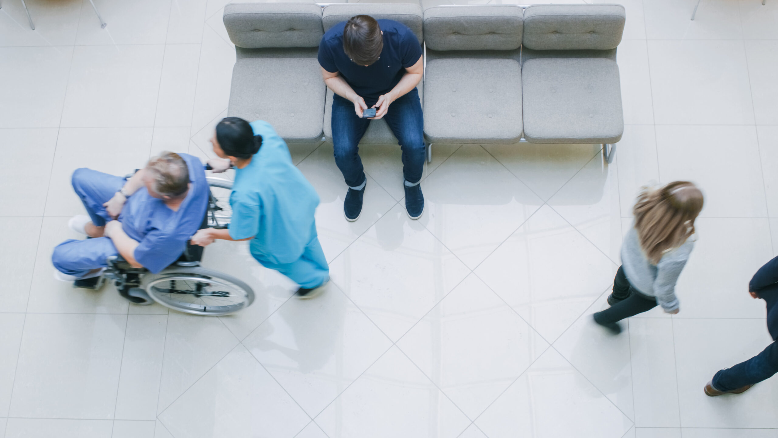 High,Angle,Shot,In,The,Hospital,Lobby,,Young,Man,Waits
